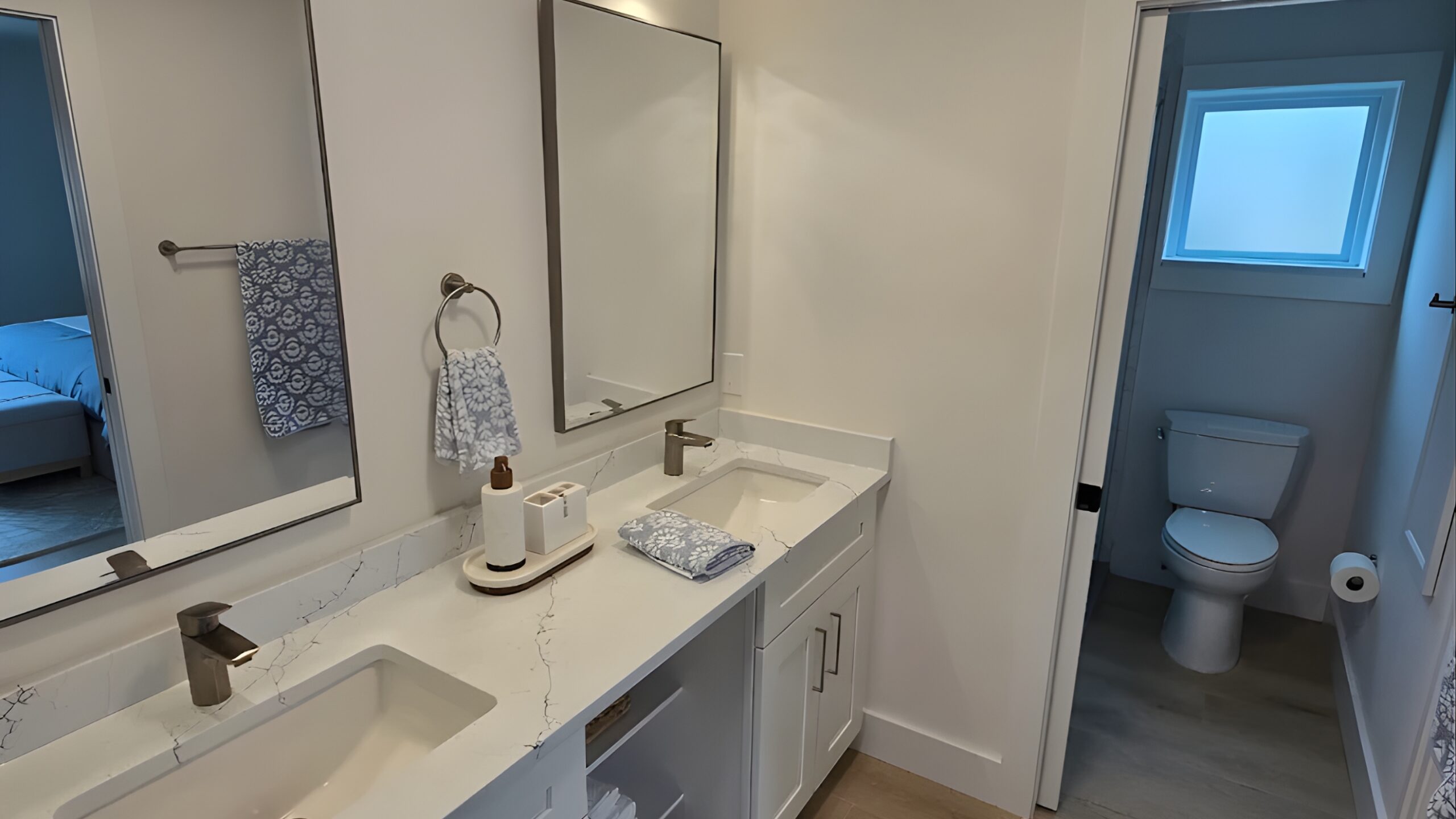 Bathroom remodeling contractor Naples FL — completed double vanity with quartz countertop, wood-look tile flooring and brushed nickel fixtures by Pro Squad Renovations